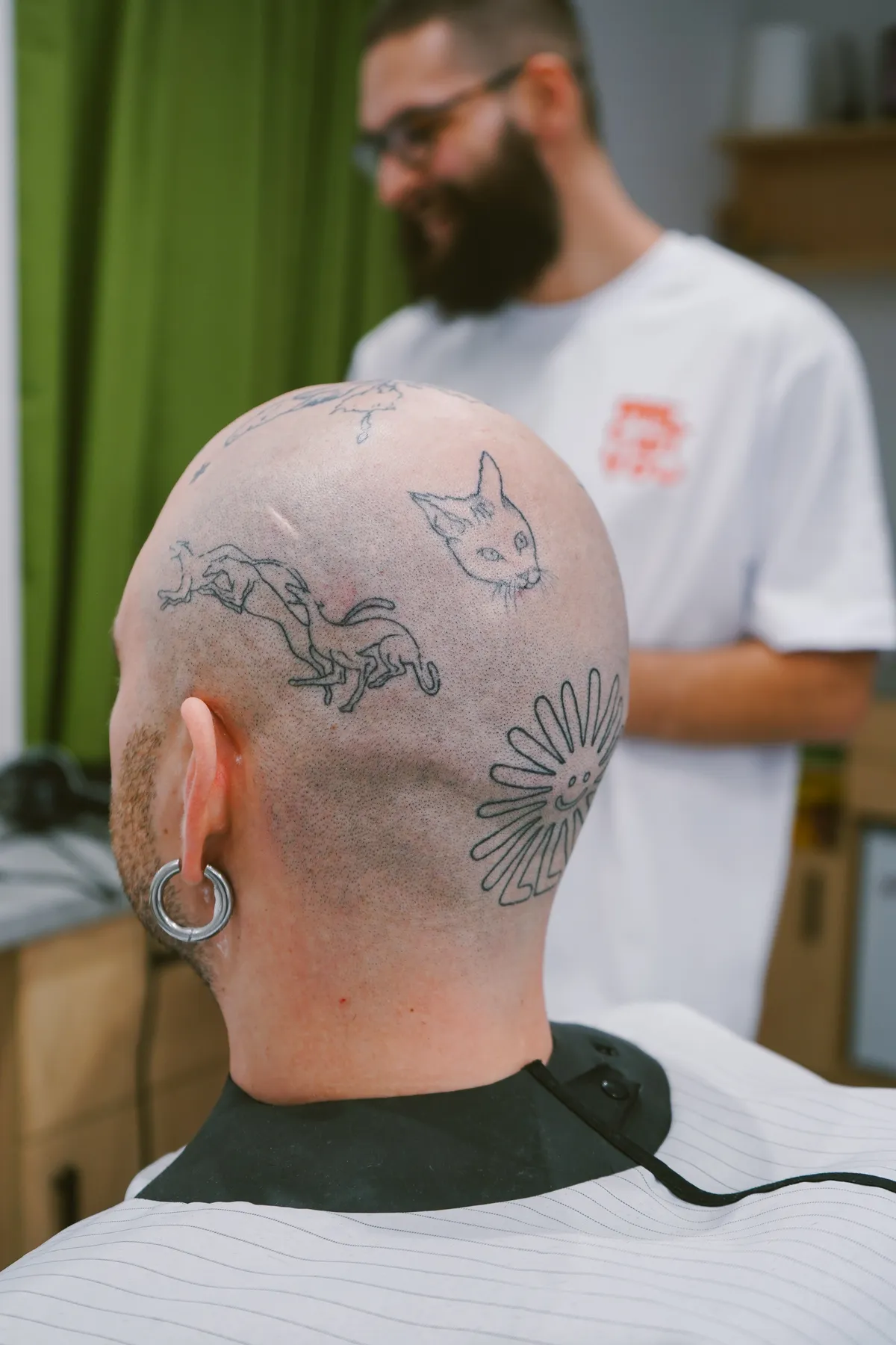 Tikko noskūta galva ar unikāliem tetovējumiem Me Cut You barbershopā. Rīgā pieejamais galvas skūšanas pakalpojums nodrošina gludu un tīru izskatu, pielāgotu individuālajam stilam. Pieredzējuši meistari piedāvā precīzu vīriešu kopšanu un unikālu pašizpausmi.